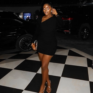 Close-up of black bodycon mini dress featuring asymmetric one-shoulder and long sleeve detail
