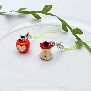 Close-up of cute 3D resin apple charms with red heart motif and bitten core design