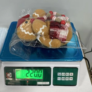 Gingerbread man gnome plush toy on an electronic scale showing 220g weight detail