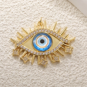 Detailed view of evil eye charm in gold finish with blue stones and small star accents