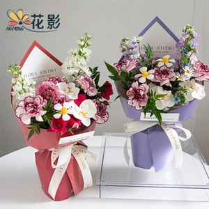 Detail of ruffled pearl floral wrapping paper on bouquets with eternal gold ribbon