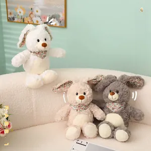 Detalle de ositos y conejos de peluche con bufandas florales en sofá blanco