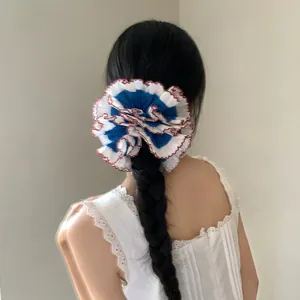 Blue and white lace scrunchie with red edges tied on a black braided ponytail