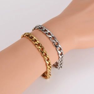 Detail of gold and silver polished 8mm Cuban link anklets on a female model's ankle