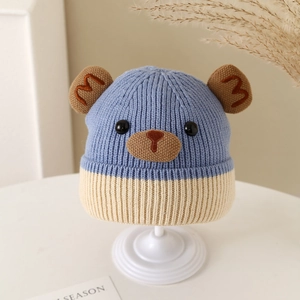 Close-up of cute knit bear hat for kids with contrasting blue and yellow colors