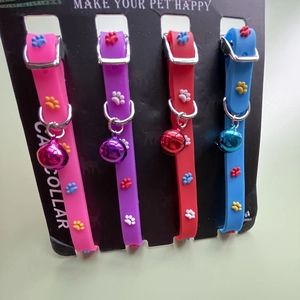 Detail view of four colorful silicone cat collars with bells and embossed paw patterns