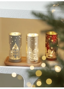 Close-up of LED Christmas lanterns with snowflake cutouts on a wooden tray