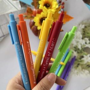 Close-up of five colorful teacher appreciation pens with inspirational quotes held in hand