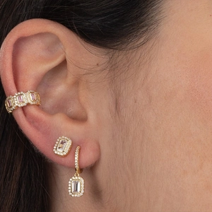 Elegant gold earrings with pink and white zircon stones shown on a female model