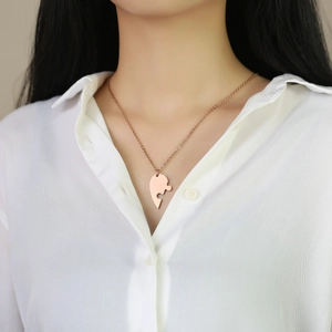 Close-up of rose gold puzzle-shaped heart pendant worn by model for friendship style