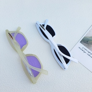 Detail view of cat eye sunglasses in white and translucent green with metallic hinges