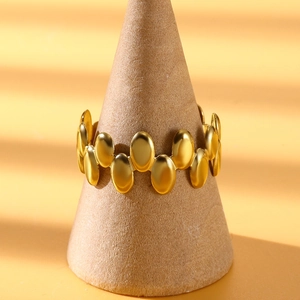Detail of a gold irregular geometric ring with linked oval plates on a cone stand