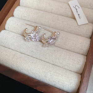 Macro shot of silver studs featuring lavender square cubic zirconia and white pearls