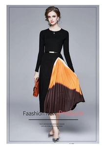 Détail de robe plissée en maille avec jupe dégradée orange et ceinture à boucle dorée