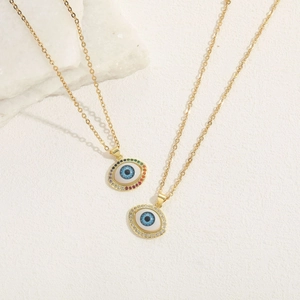 Chic 14K gold plated evil eye necklace with colorful zircon stones on textured background