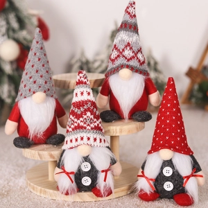 Detail of four Christmas gnomes with knit hats on wood shelf for festive home decoration