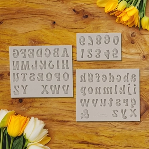 Detail showing uppercase and lowercase alphabet silicone molds on a wood background
