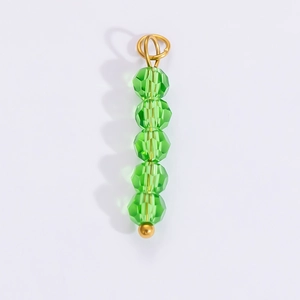 Detailed view of green faceted crystal bead pendant with gold ring for DIY jewelry making