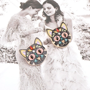 Macro detail of artistic black cat brooch with colorful rhinestones and floral pattern