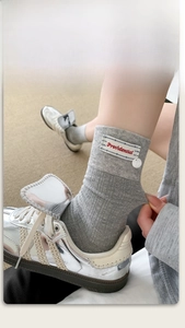 Detail of gray mid-tube socks featuring a tri-color fabric label and premium knit texture