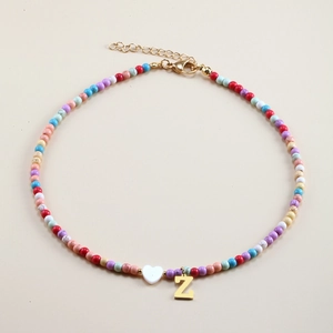 Close-up of colorful beaded necklace featuring a white heart and golden letter Z pendant