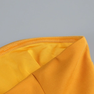 Detail shot of the waist stitching and knit texture on the yellow tube party dress