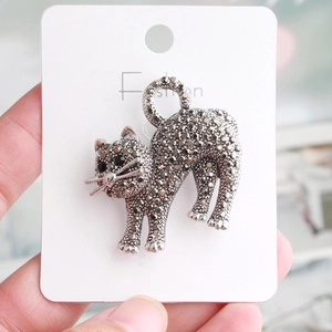 Close-up of cat-shaped brooch with vintage silver finish and shimmering pavé stones