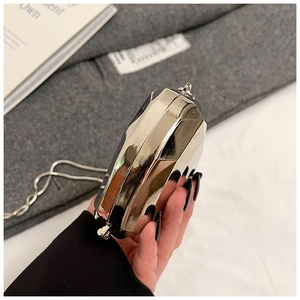 Detailed close-up of a mini heart-shaped silver metallic chain bag with geometric facets