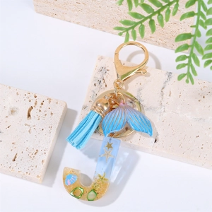 Detail of blue resin letter J keychain with starfish, seashell and gradient mermaid tail