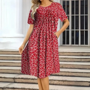 Détail d'une robe rouge à imprimé fleuri avec col rond et manches courtes en plein air