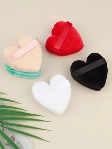 Flat lay of colorful heart-shaped flocked makeup puffs with satin finger straps