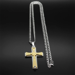 Detailed view of silver Cuban chain with a two-tone gold and silver cross pendant
