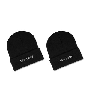Deux bonnets en maille noire 10's baby brodés pour l'hiver sur fond blanc immaculé