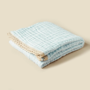 Detailed close-up of 6-layer cotton muslin baby blanket with delicate lace trim