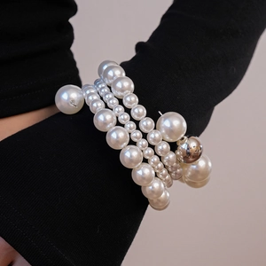 Détail d'un bracelet de perles multicouches avec perles de tailles variées et bille en métal