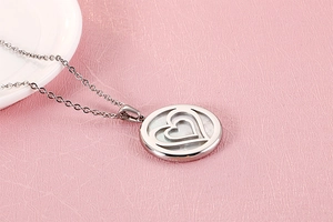Detailed macro view of a silver double heart pendant with mother-of-pearl inlay and O-chain