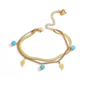 Double-layered gold chain bracelet with blue beads and heart charm on white background
