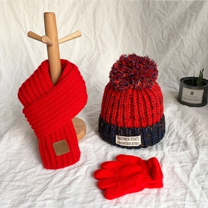 Red winter knit set for kids featuring a warm beanie with pompom, scarf, and gloves