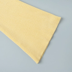 Detail of pale yellow ribbed knit texture and soft fabric on sleeve cuff and hemline
