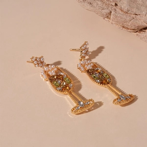 Elegante goldene Weinglas-Ohrringe mit Perlen und Kristallen auf neutralem Steindisplay