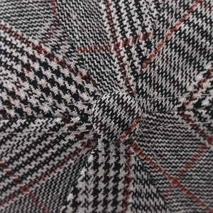 Macro shot of plaid embroidery baseball cap showing black white red tweed fabric and top button