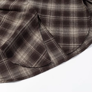 Macro shot of the brown plaid fabric texture and hemline details on y2k crop top