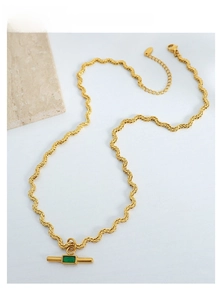 Detail of a gold rope chain necklace featuring a rectangular green gemstone pendant
