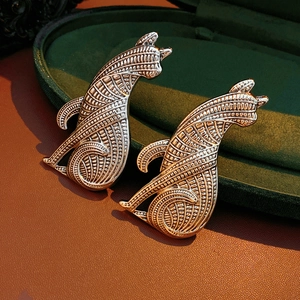 Detailaufnahme von Vintage-Welpen-Broschen aus Metall mit aufwendigen floralen Reliefs