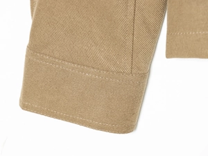 Detailed macro view of khaki twill woven fabric with precise double-needle stitching quality