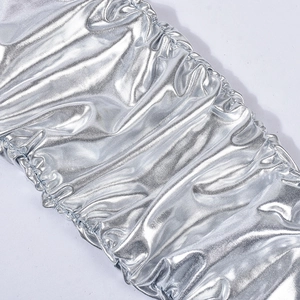 Makroaufnahme von silbernem Metallstoff mit flüssigem Glanz und elastischen Falten