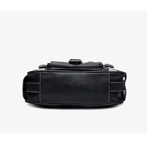 Detailed macro view of black lychee grain leather with white contrast stitching and hardware