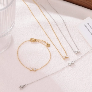 Parure de bijoux élégante avec nœud, comprenant un collier et un bracelet dorés et argentés