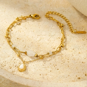 Détail du bracelet double chaîne dorée avec pierre en goutte et fermoir mousqueton