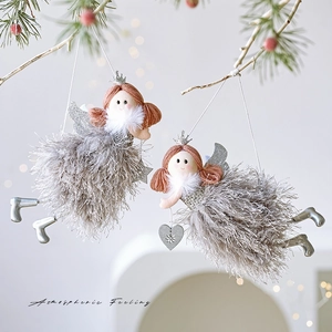 Cute gray plush Christmas angel ornaments with pink braids on a festive tree branch